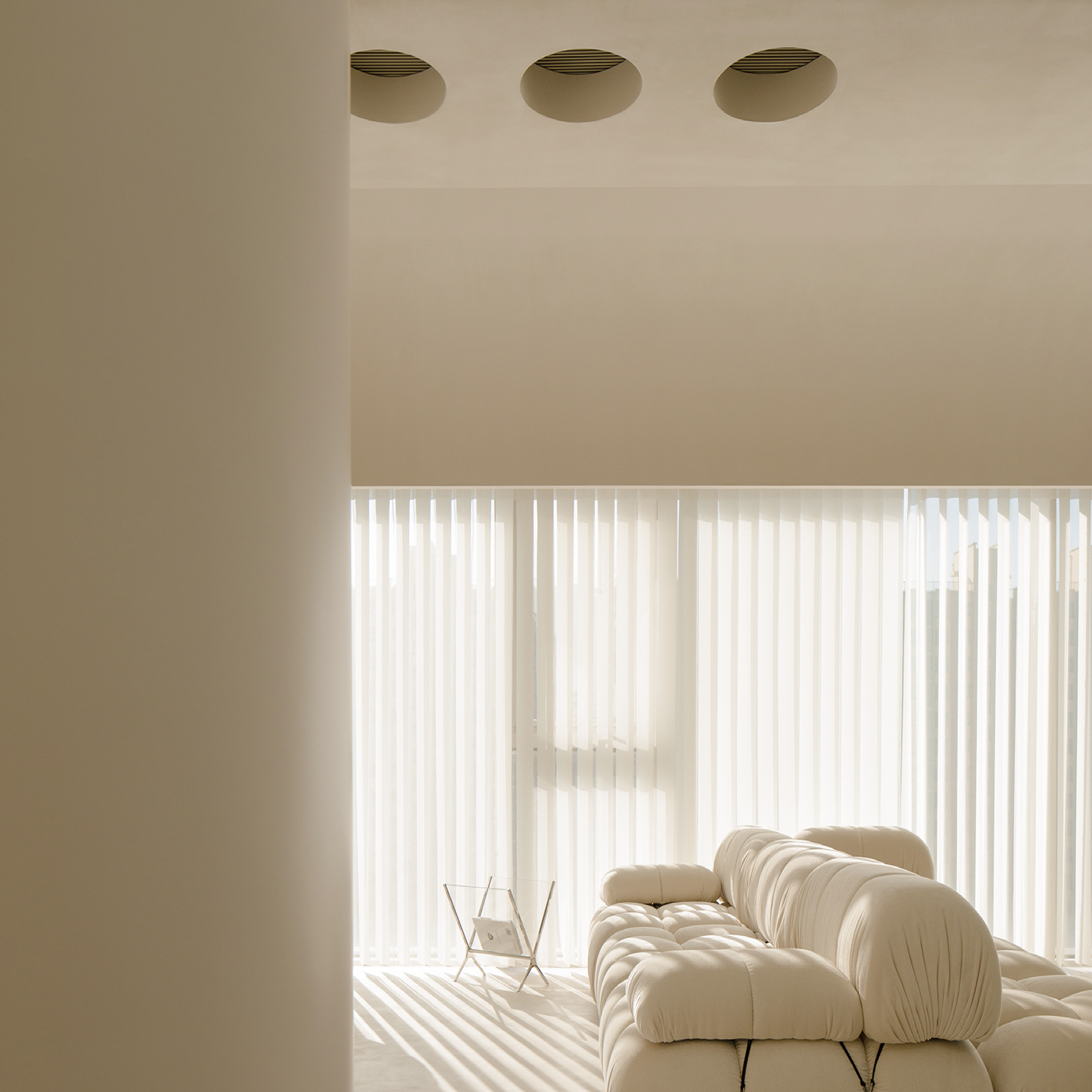 韓式奶油風客廳光影：透過大面積落地簾幕引入柔和採光，搭配圓潤飽滿的模組化沙發，在暖米色調基礎中營造出靜謐且具層次感的生活氛圍。