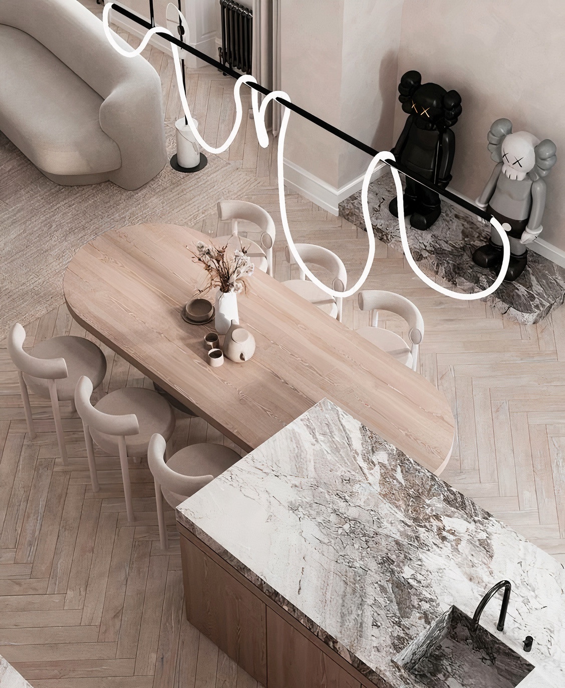 天然石材中島設計案例：俯瞰大理石中島連結圓角木質長餐桌，搭配奶油色系圓弧餐椅與獨特的霓虹線條燈具，在人字拼木地板與藝術公仔佈置下，營造出極具設計感與玩味的現代開放式公領域空間。