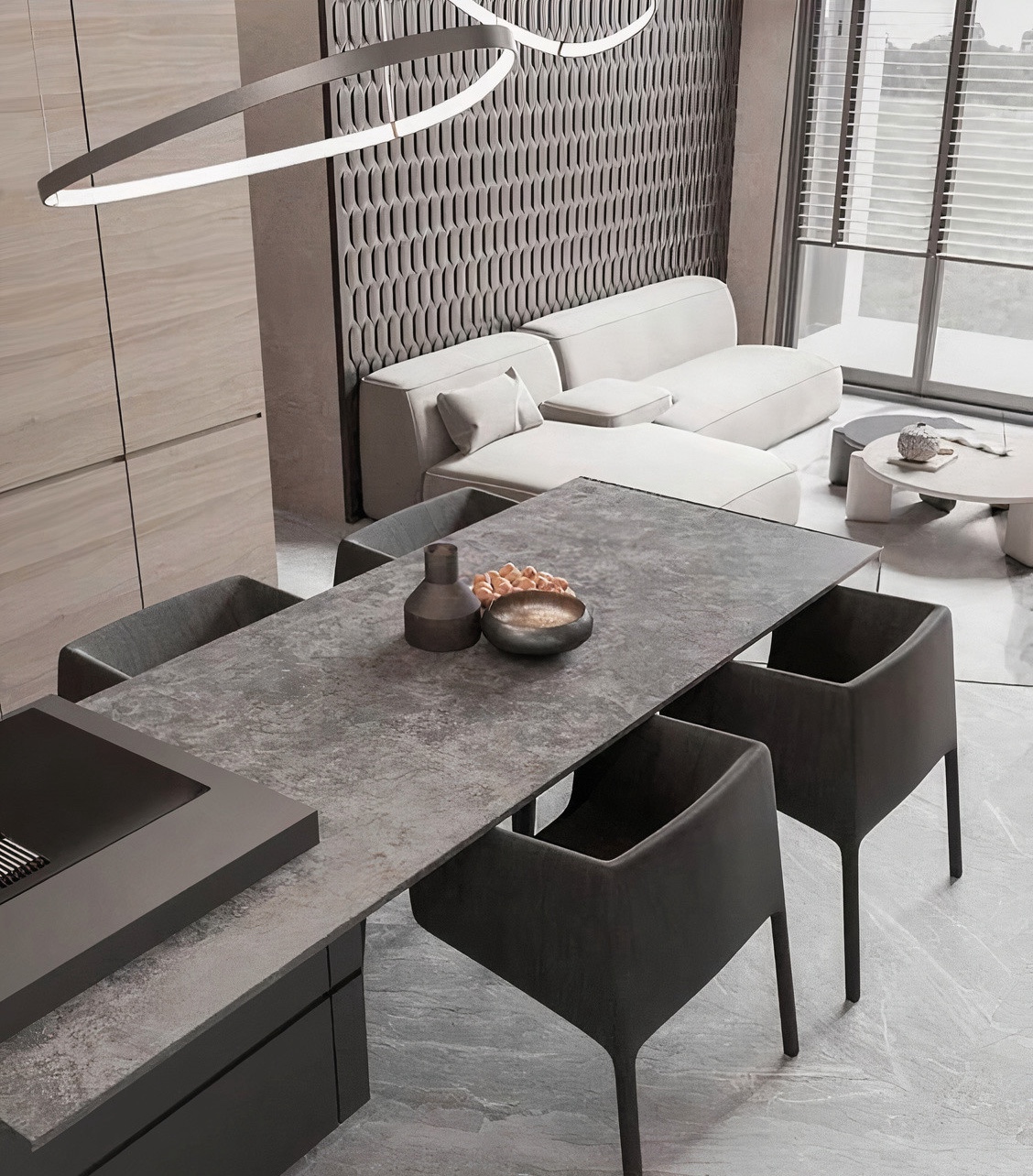 陶板中島設計案例：深灰色陶板中島餐桌展現粗獷岩石質感，搭配俐落的黑色極簡餐椅與環形藝術燈具，在開放式客廳與格柵壁板的背景下，營造出具備現代建築感的冷調奢華氛圍。